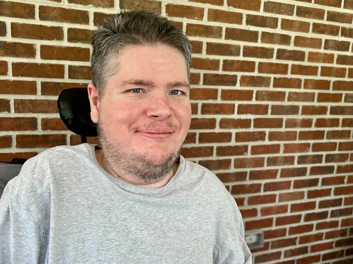 A portrait of me, a disabled white guy with short brown hair sitting in a wheelchair.
